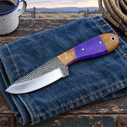 Purple-and-wood-handled knife on denim at a chuckwagon